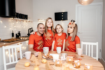 A family in red T-shirts celebrating Christmas in the kitchen