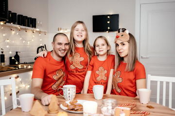 A family in red T-shirts celebrating Christmas in the kitchen