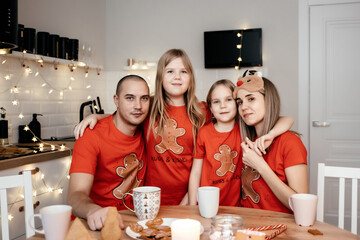 A family in red T-shirts celebrating Christmas in the kitchen