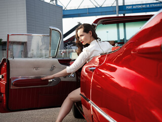 60-s oldtimer red Cadillac and a beautiful young girl