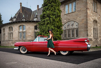Old-timer red Cadillac and a beautiful young girl - obrazy, fototapety, plakaty