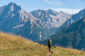 Fototapeta na wymiar Woman hiking alone in the mountains on the Dolomites - Italian Alps in late summer. Val di Fassa, Trentino.