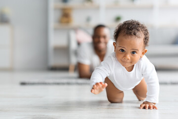 Adorable Black Infant Baby Crawling Away From Father At Home