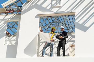  Foreman man wearing a safety engineer helmet holding blueprints talks to Project Manor meets the...