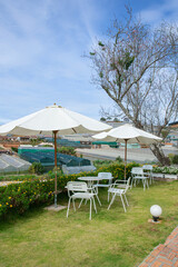 Beautiful backyard with green grass, blue sky, farm house, white table and chairt in Da Lat, Lam Dong, Viet Nam