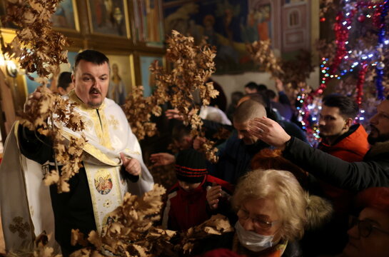 Bosnian Orthodox people take oak from priest Marko Males, after prayers on the eve of Orthodox Christmas in Church of the Holy Mother of God in Zenica