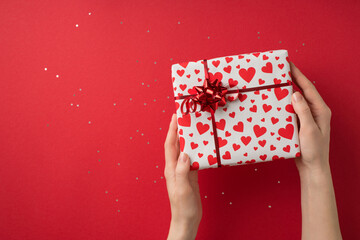 First person top view photo of valentine's day decor glitter girl's hands demonstrating gift box in...