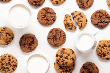 Fresh cookies with chocolate chips and milk pattern on white background.