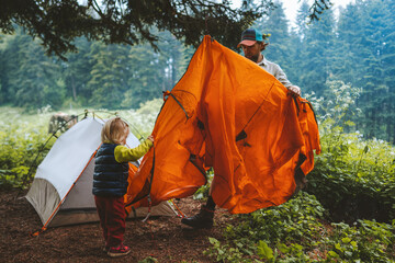 Child and father are setting camping tent family vacations travel hiking outdoor in forest adventure trip healthy lifestyle - obrazy, fototapety, plakaty