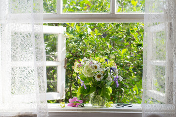 Bouquet of garden flowers on opened window