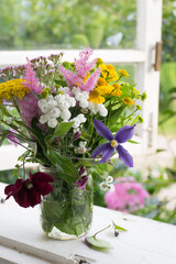 Bouquet of garden flowers on opened window