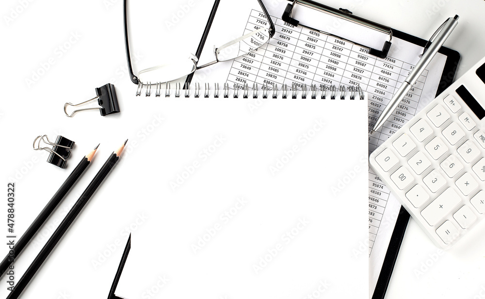 Poster an empty notepad with a pen,office tools and graphs on the desktop. copy space