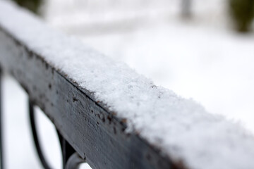 Snow on the black wrought iron railing