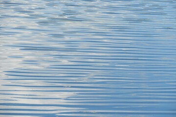Ripples on light blue calm water surface, natural background