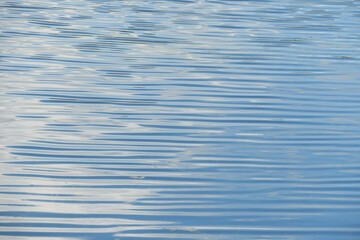 Calm light blue river water ripples texture, natural water background