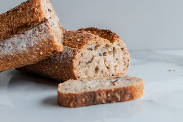 Close up of a sliced baguette on a white background.