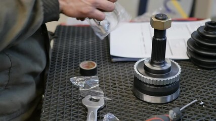 the hands of the auto repairman unpacked and prepared a new spare part for installation on the car front CV joint. Slow motion