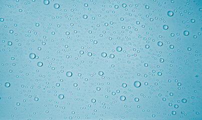 Wassertröpfchen auf hellblauem Untergrund bilden ein formatfüllendes Muster