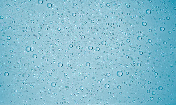 Wassertr&ouml;pfchen auf hellblauem Untergrund bilden ein formatf&uuml;llendes Muster