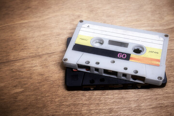 Fototapeta premium Two vintage audio cassettes lie on the wooden table