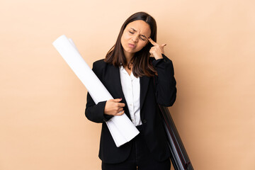 Young architect woman holding blueprints over isolated background making the gesture of madness...