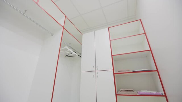 Room for clothes in light colors. Dressing room in white.