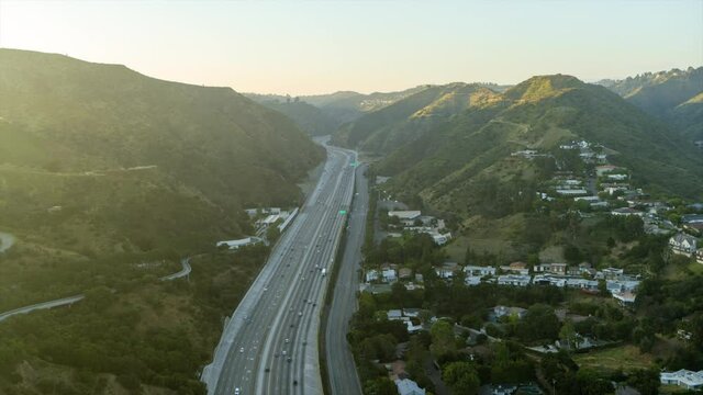 Aerial Moving Forward High Above The 405 Interstate With Rolling Hills And Hazy Sunlight - Los Angeles, California
