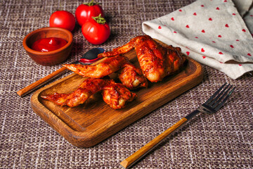 Grilled or roasted spicy chicken wings with tomatoes