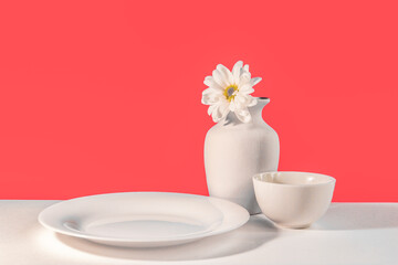 Minimalist still life with vase, chrysanthemum flower, and white dishes isolated on pink background, product stand, kitchenware mock-up