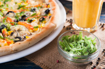 Pizza close-up with green cheese on a white plate