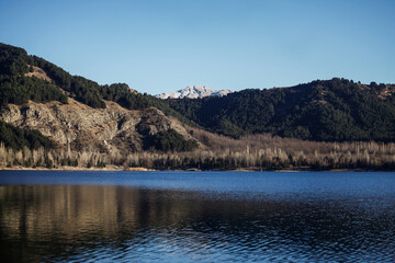 Fototapeta na wymiar Scenic view of lake and mountains against clear blue sky, horizontal photo