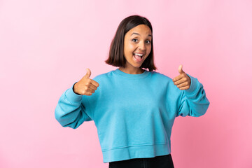 Young latin woman isolated on pink background giving a thumbs up gesture