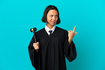 Judge over isolated blue background making the gesture of madness putting finger on the head