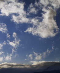 Blue sky with clouds and mountains at evening