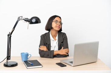 Young business mixed race woman working at office keeping the arms crossed