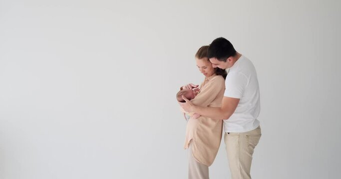 Parents holding and stroking their baby son over white background