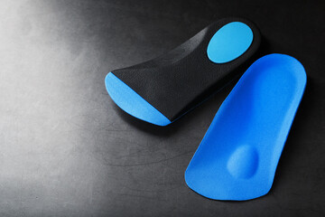Orthopedic insoles for correction of pronation of the foot on a dark background.