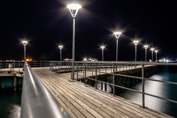 Illuminated sea pier at night - Powered by Adobe