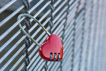 Cadenas rouge en forme de coeur accroché à un pont