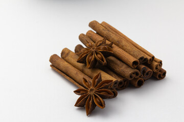 cinnamon sticks and anise stars on white background, healthy eating, copy space, horizontal