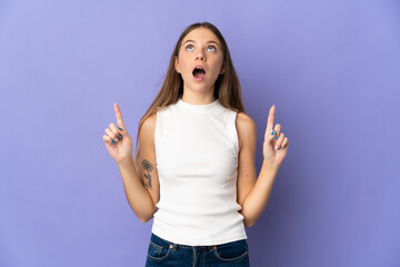 Young Lithuanian woman isolated on purple background surprised and pointing up