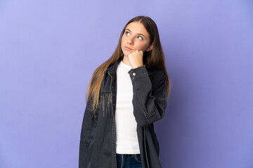 Young Lithuanian woman isolated on purple background and looking up