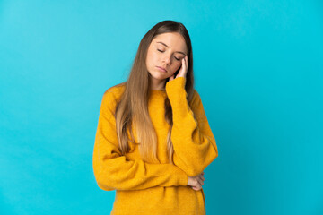 Young Lithuanian woman isolated on blue background with headache