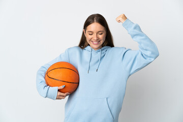 Young Lithuanian woman playing basketball isolated on white background doing strong gesture