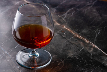 a glass of cognac on a dark background