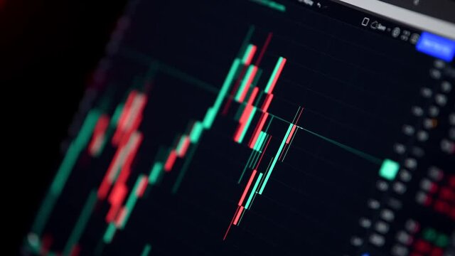 The graph with the crypto currency evolution. Online quotes at the stock exchange. 4K video showing the market movement, viewing the app on a laptop screen. Red and green candles.