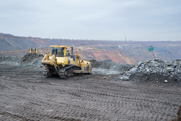 Bulldozer work in the iron ore quarry. Laying and cleaning roads with a crawler bulldozer in open-pit mining