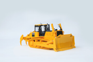 Fototapeta premium Yellow bulldozer on white background, scale model of a large yellow crawler bulldozer.