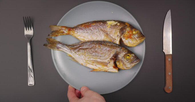 Closeup footage of serving whole grilled salt water fish