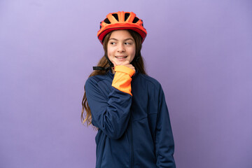 Little caucasian girl isolated on purple background looking to the side and smiling